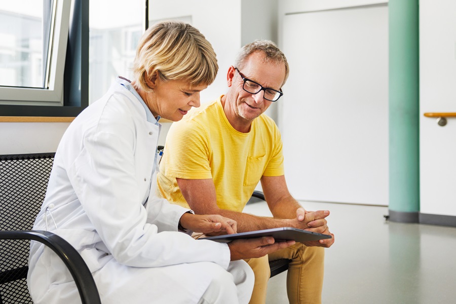 Man & doctor discussing hospital treatment