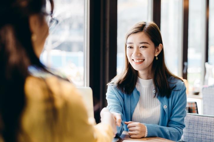 A girl shaking hand with another colleague