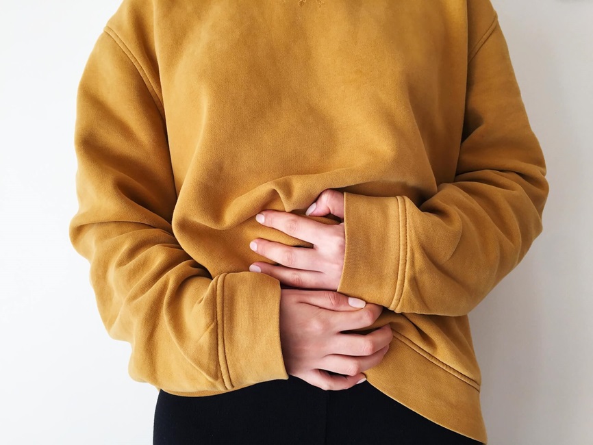 Person holding hands near stomach