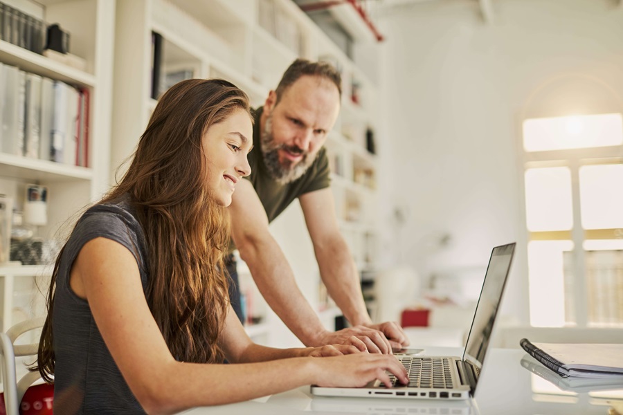 Couple using laptop on desk