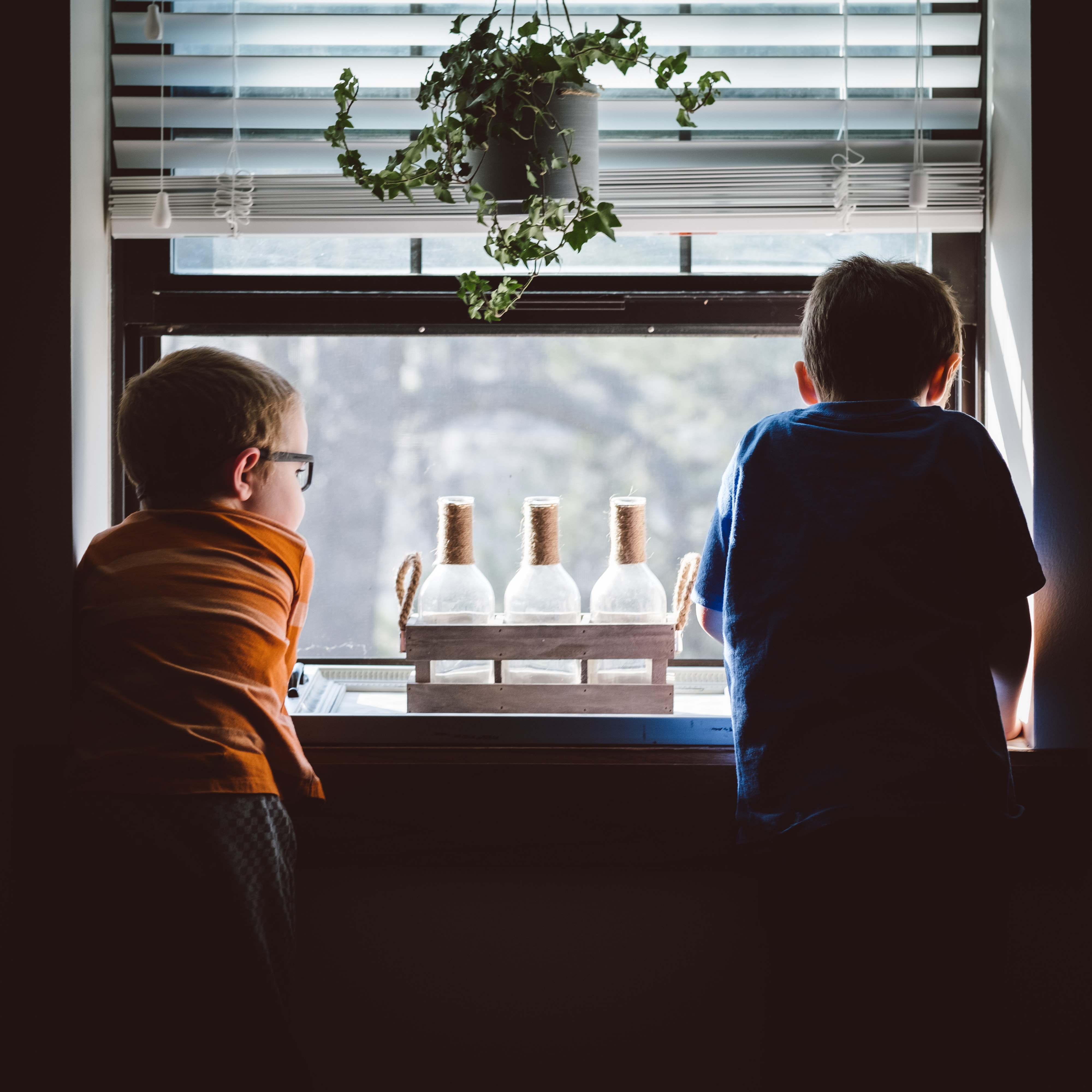 two kids watching outside while staying at home